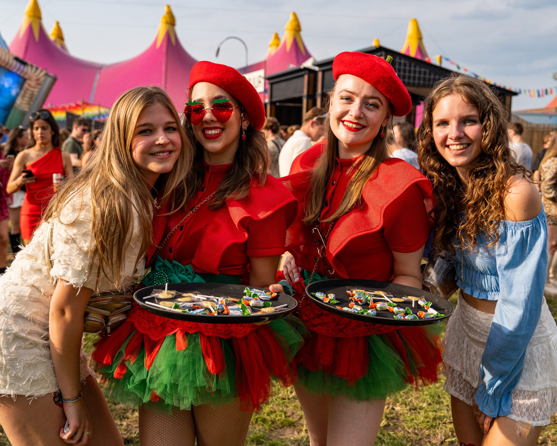 Candy Girls in aardbeienkostuum delen snoep uit op een festival