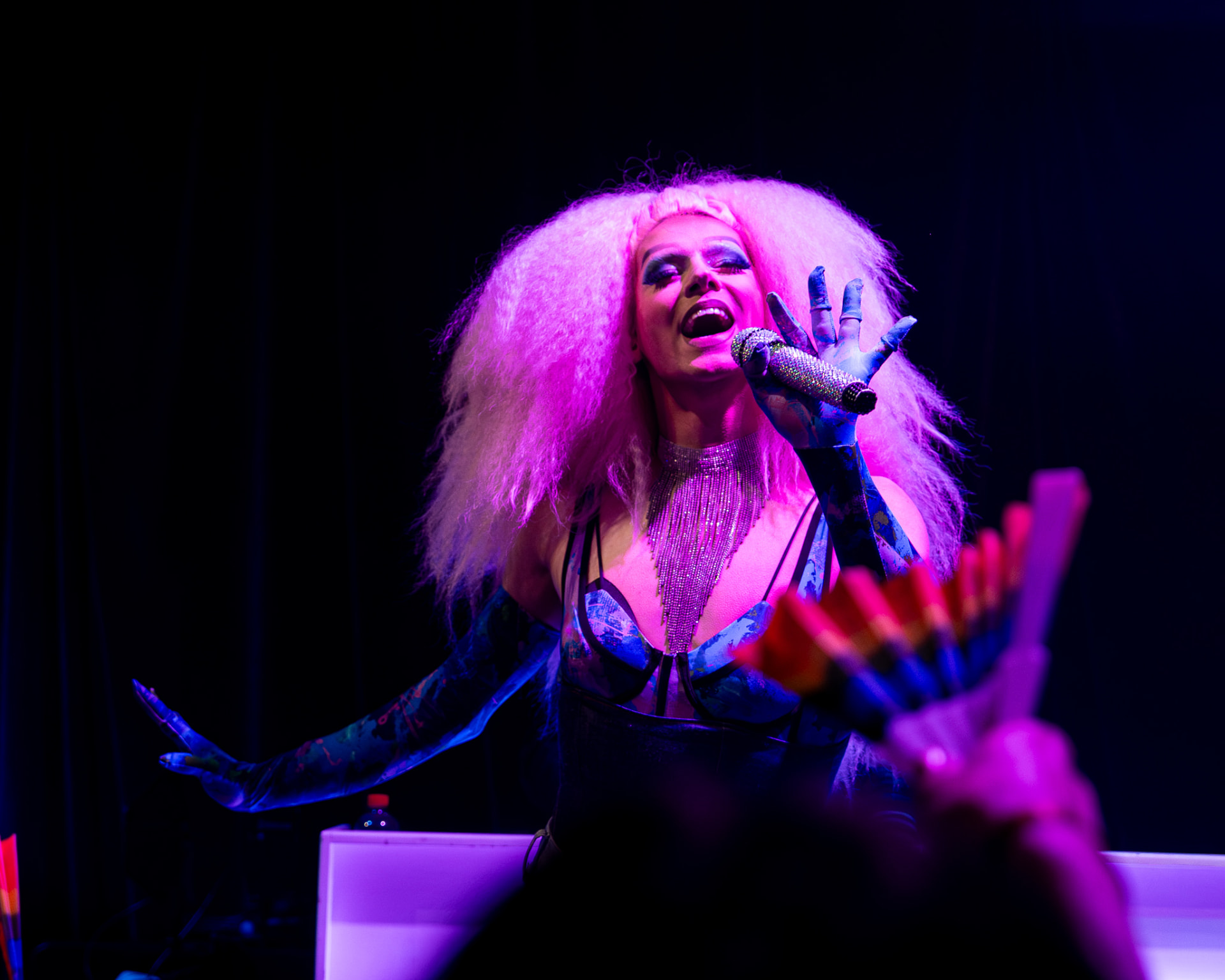 Drag performer met roze pruik zingt live in het theater