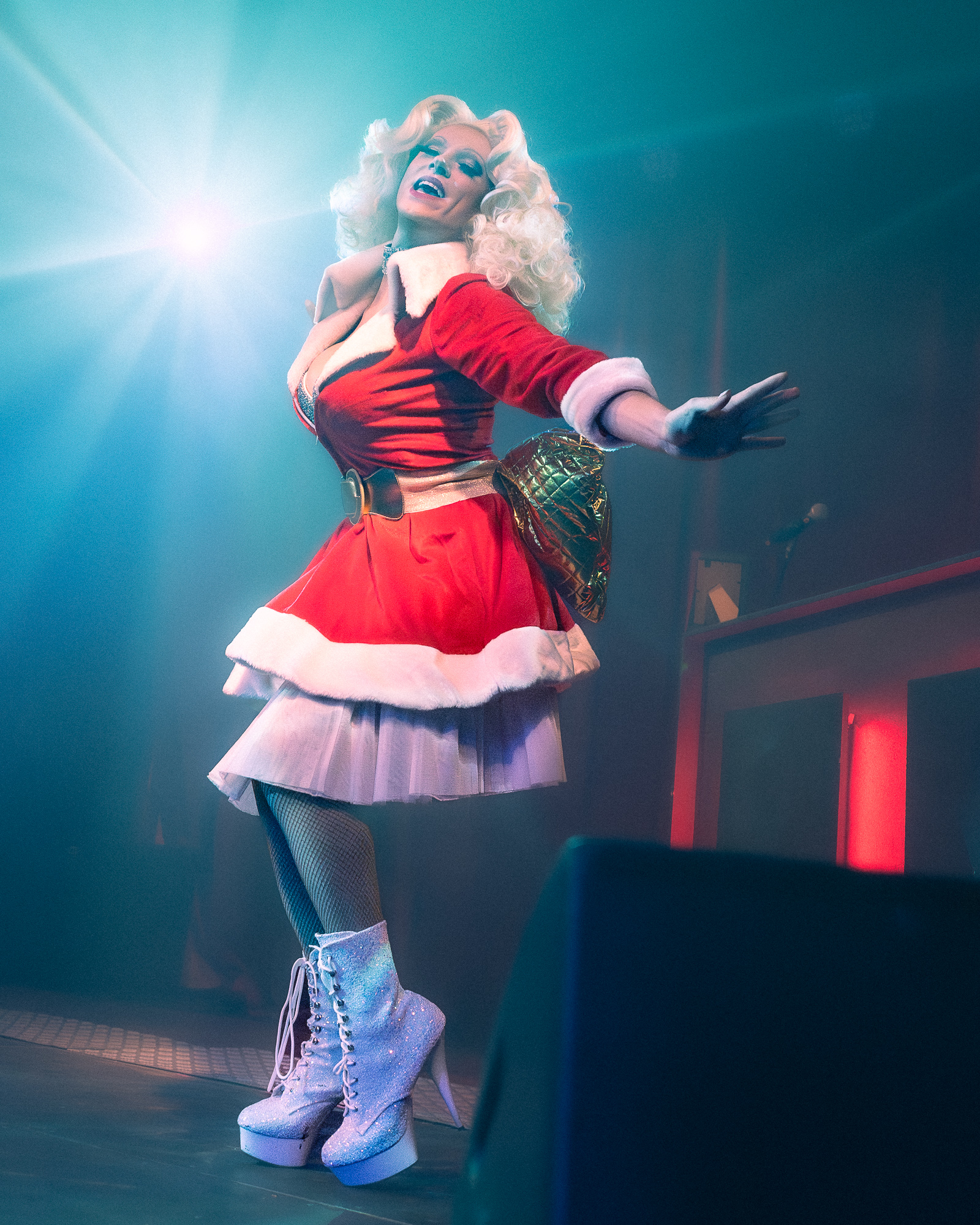 Vera Virgin in rood kerstkostuum met glitterlaarzen op het podium