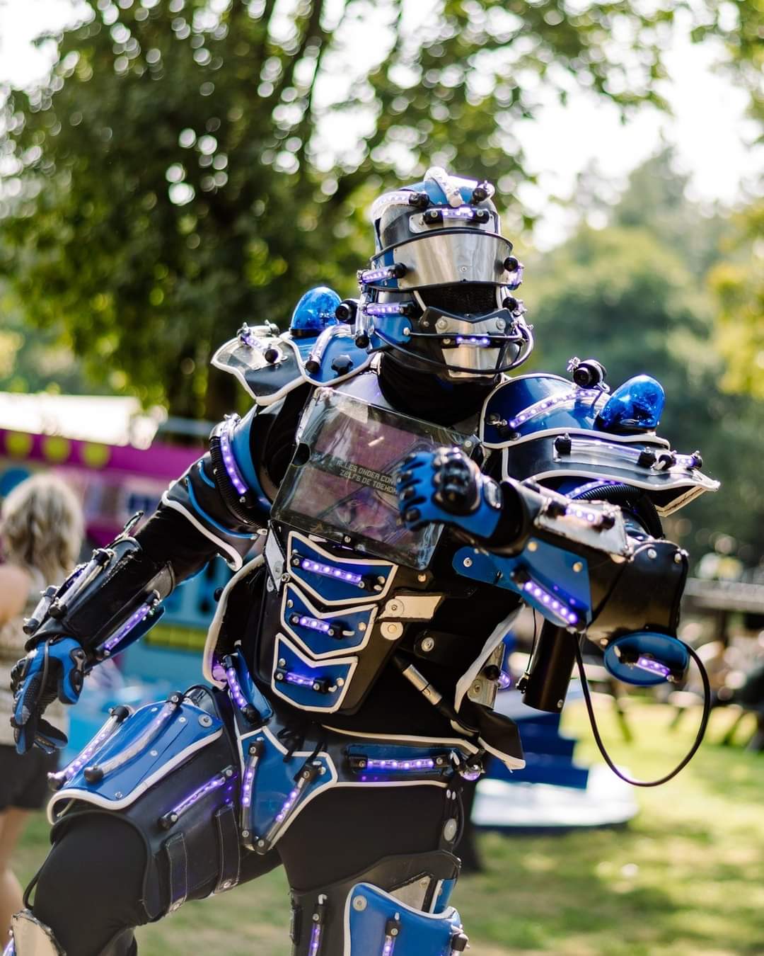 LED robot typetje in blauw oplichtend kostuum op het festivalterrein