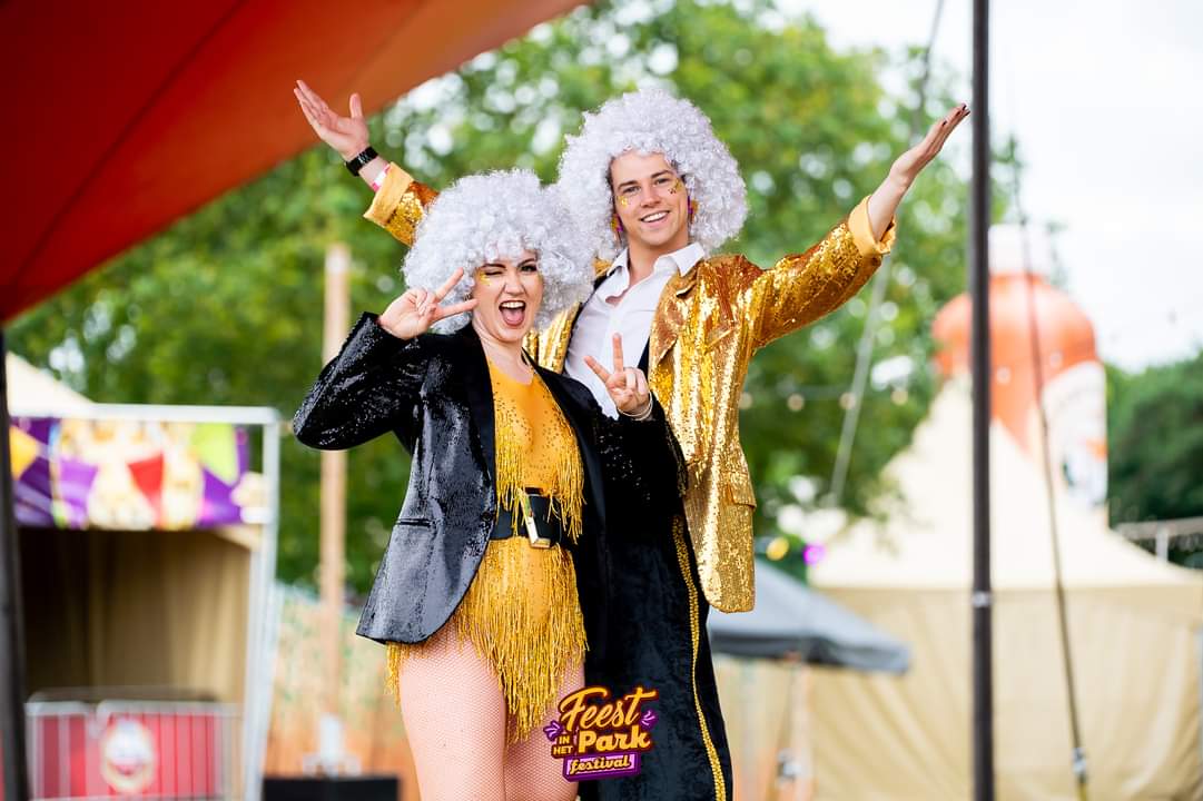 Disco Duo in gouden glitteroutfits poseert vrolijk voor het publiek