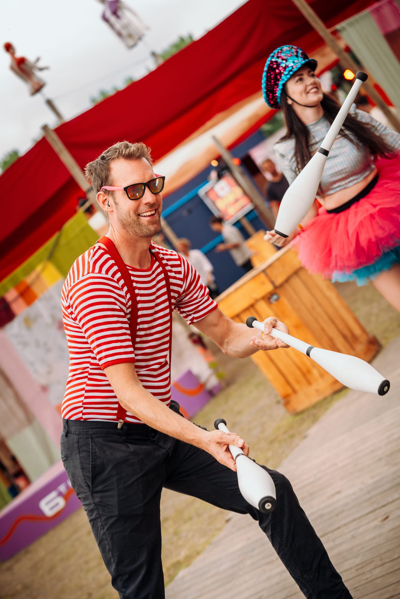 Jongleur met kegels en danseres op stelten tijdens een festivalact