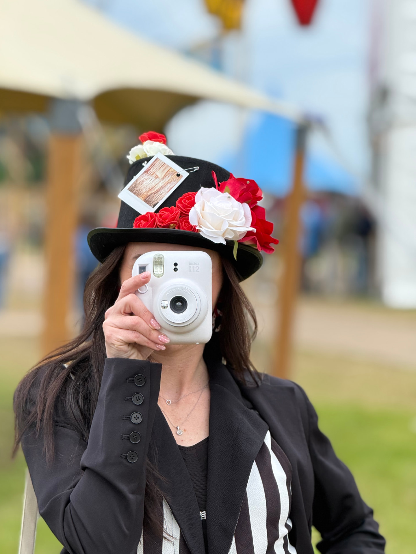 Polaroid Lady met bloemenhoed maakt een foto met een instant camera