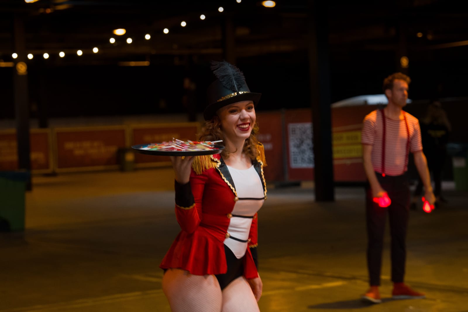 Candy Girl in rood circuskostuum met een schaal snoep tijdens een event