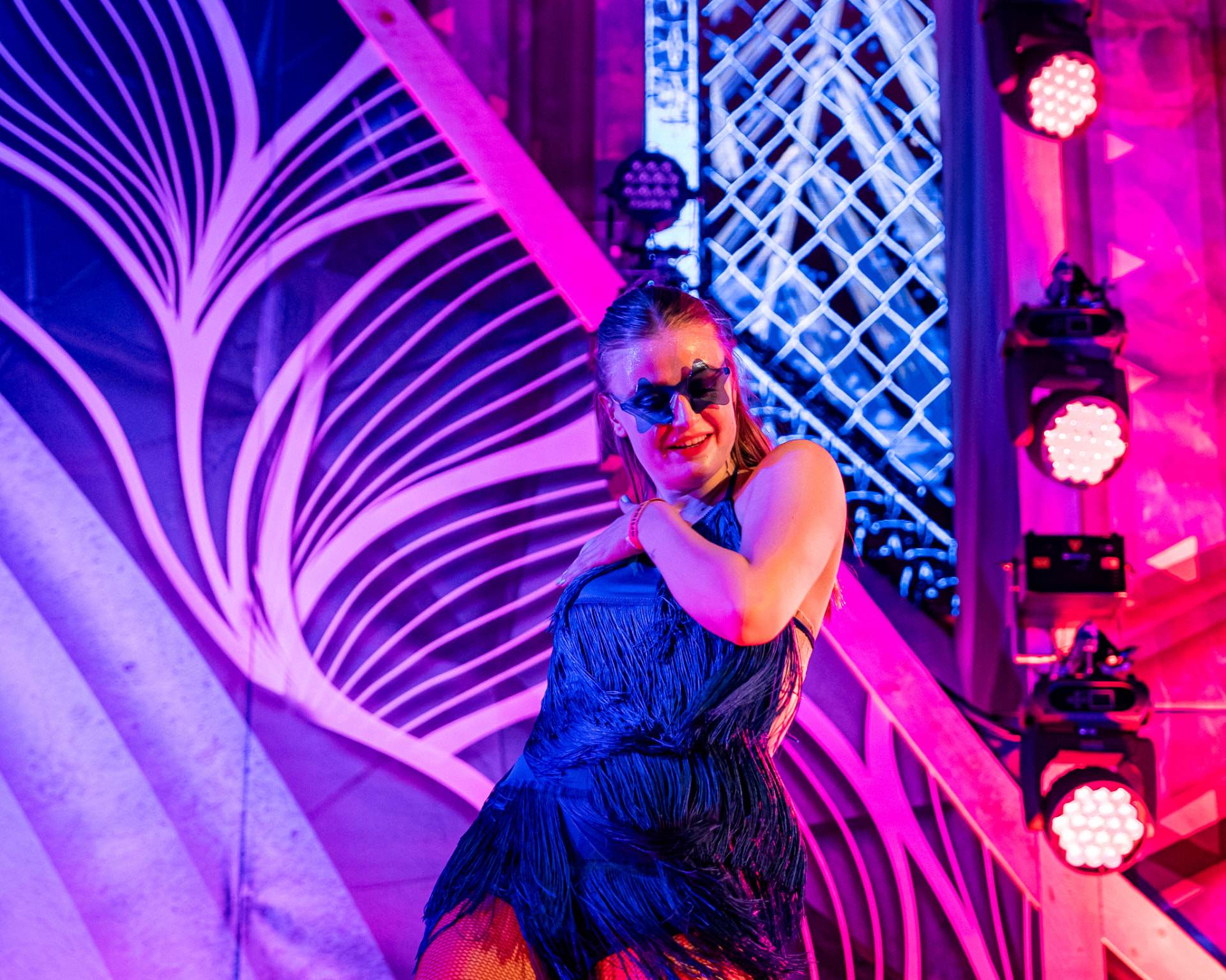 Danseres in blauw franjekostuum in paars podiumlicht