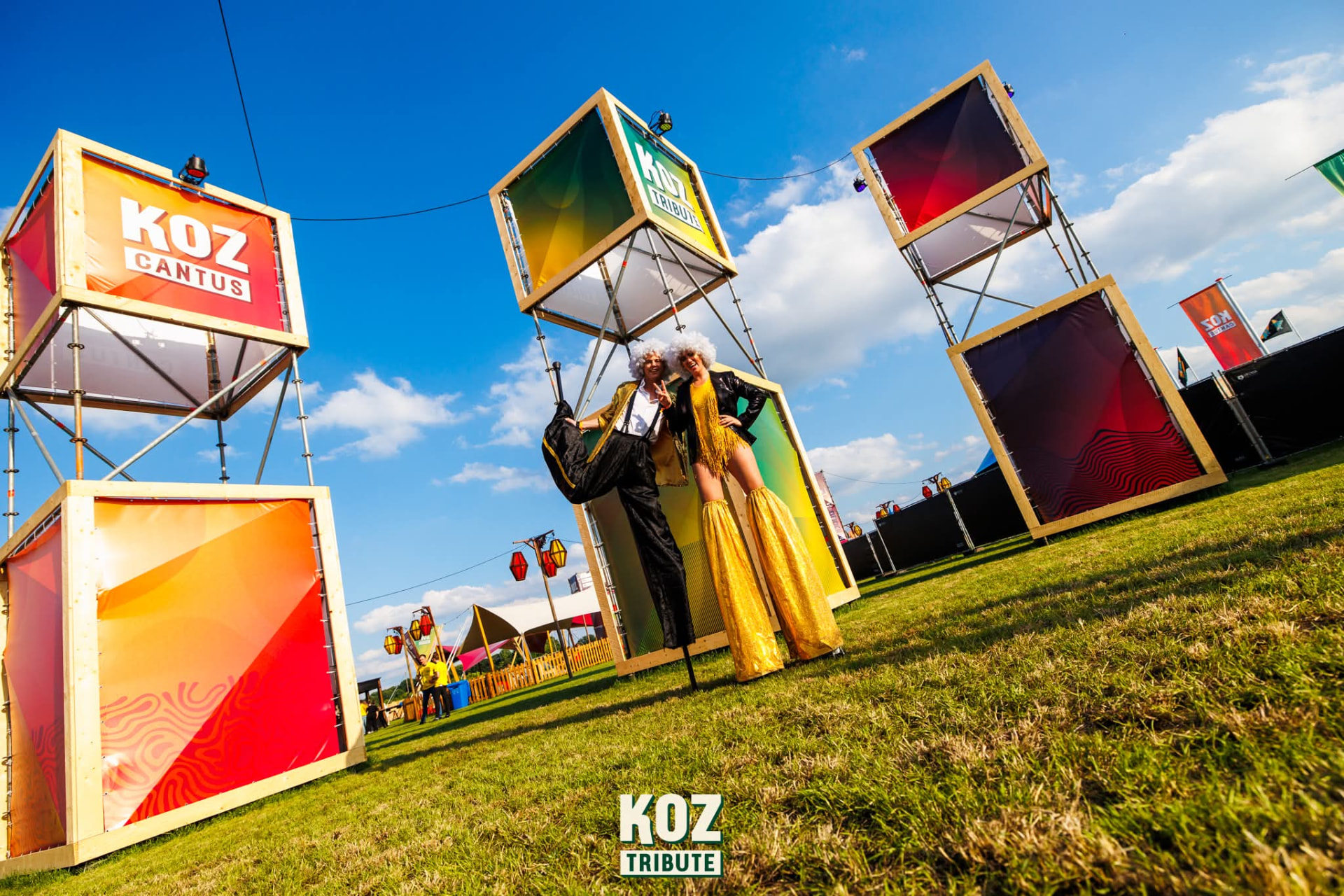 Steltlopers in gouden kostuums op het festivalterrein van KOZ